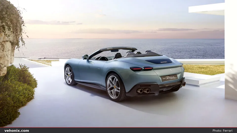 2026 Ferrari Roma Spider in Celeste blue, rear three-quarter overlooking the sea