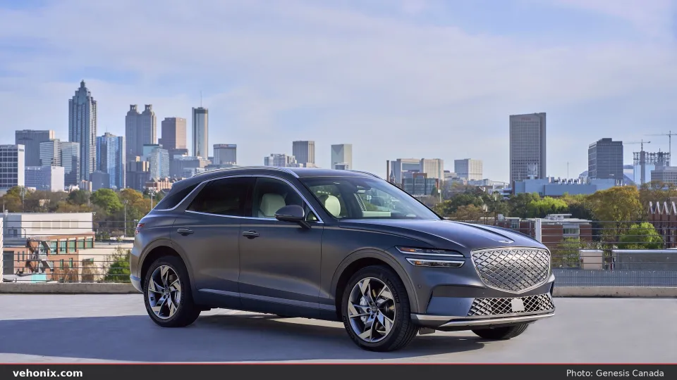 2026 Genesis Electrified GV70 in grey, front three-quarter on a rooftop with city skyline