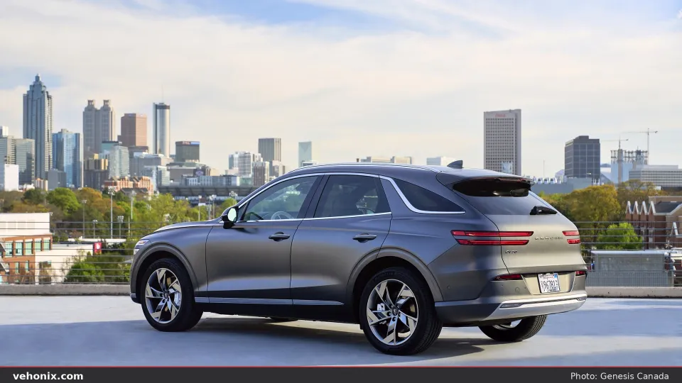 2026 Genesis Electrified GV70 in grey, rear three-quarter on a rooftop overlooking the city