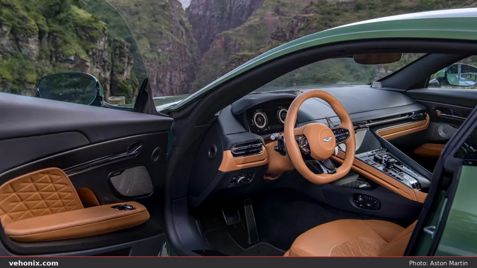 2026 Aston Martin DB12 driver seat, tan steering wheel and open door with quilted leather