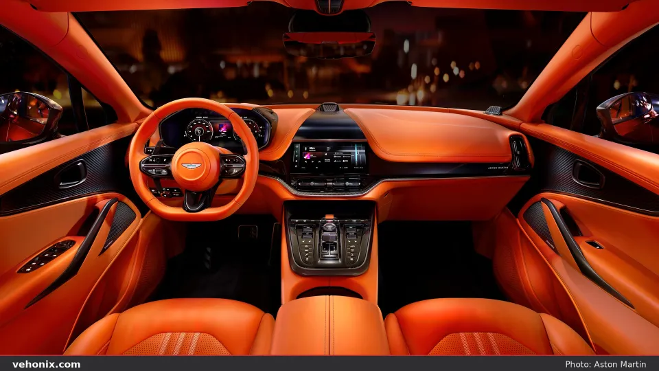 2026 Aston Martin DBX707 cockpit with orange leather steering wheel and dual screens
