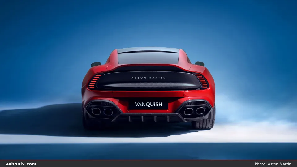 2026 Aston Martin Vanquish in red, straight-on rear studio view with quad exhausts