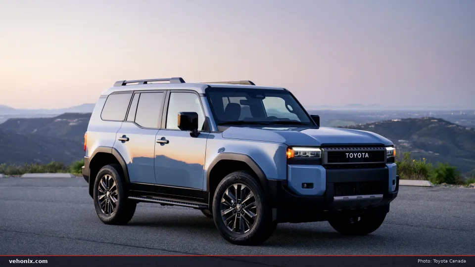 2026 Toyota Land Cruiser in Heritage Blue, front three-quarter view at dusk