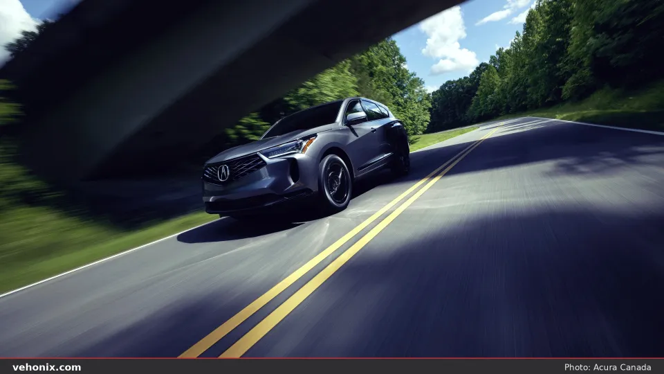 2026 Acura RDX SH-AWD front three-quarter view under a highway overpass