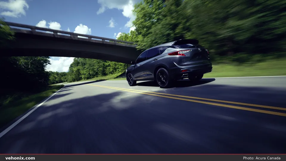 2026 Acura RDX SH-AWD rear three-quarter view driving under an overpass