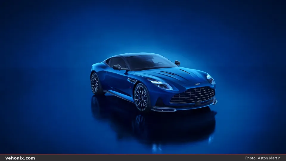 2026 Aston Martin DB12 S in dark blue, front three-quarter studio view with lights on