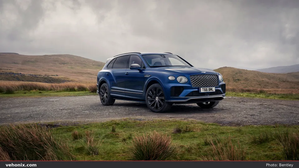 2026 Bentley Bentayga EWB in blue, front three-quarter view on a highland road