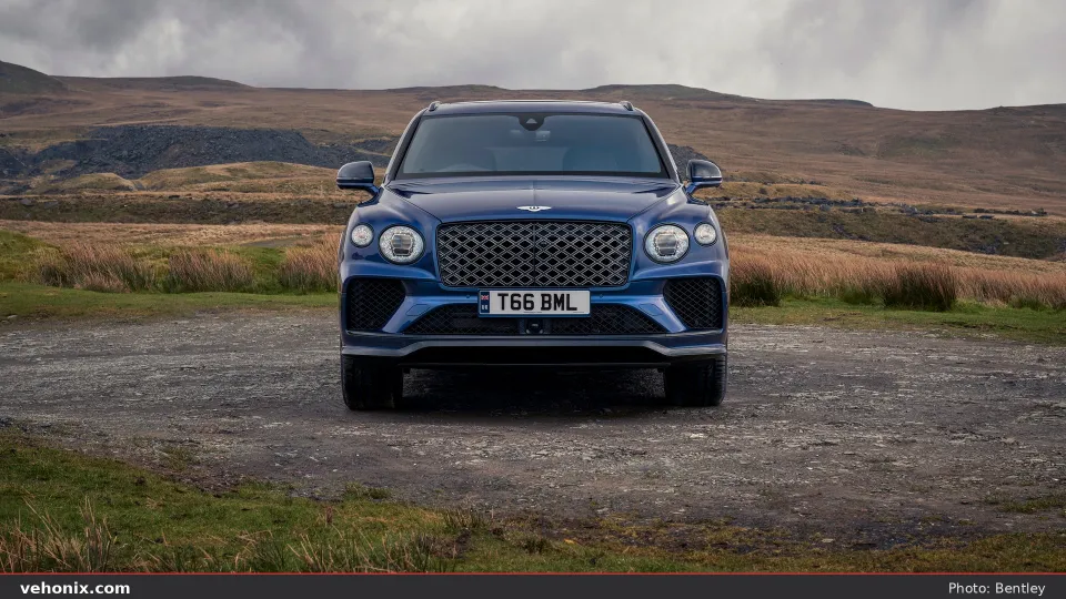 2026 Bentley Bentayga EWB in blue, head-on front view on a gravel highland turnout