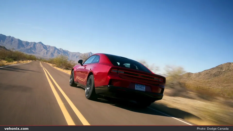 2026 Dodge Charger Daytona R/T in red, rear three-quarter on a desert highway