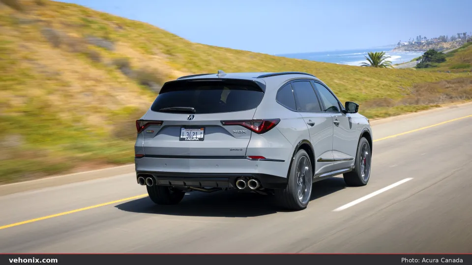 2026 Acura MDX SH-AWD Type S in silver, rear three-quarter view driving on a coastal road