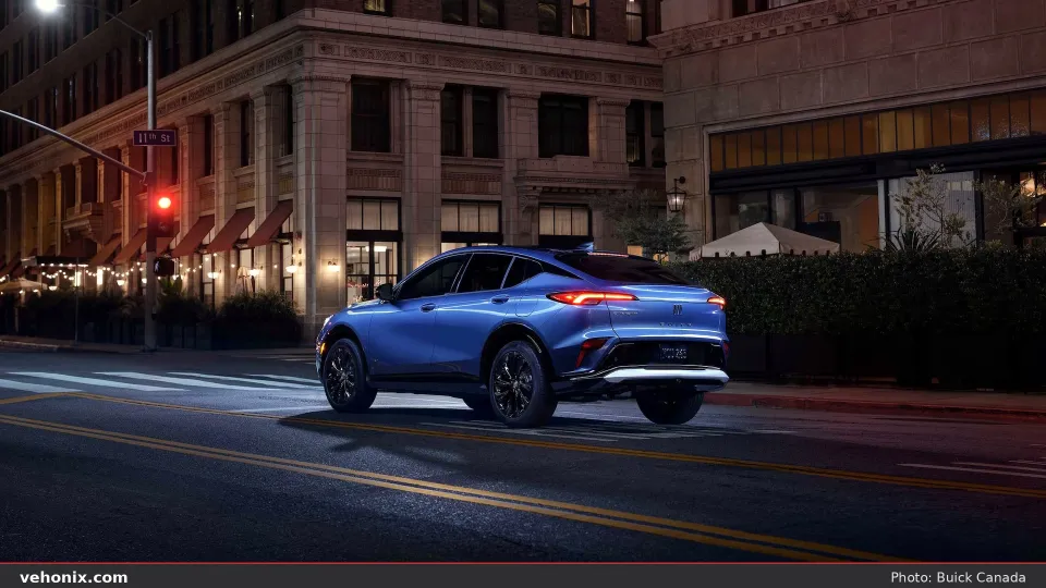 2026 Buick Envista in blue, rear three-quarter on a city street at night