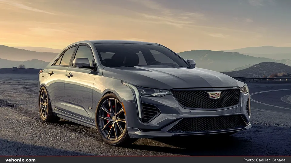 2026 Cadillac CT4-V in gray, front three-quarter on a mountain road at sunset
