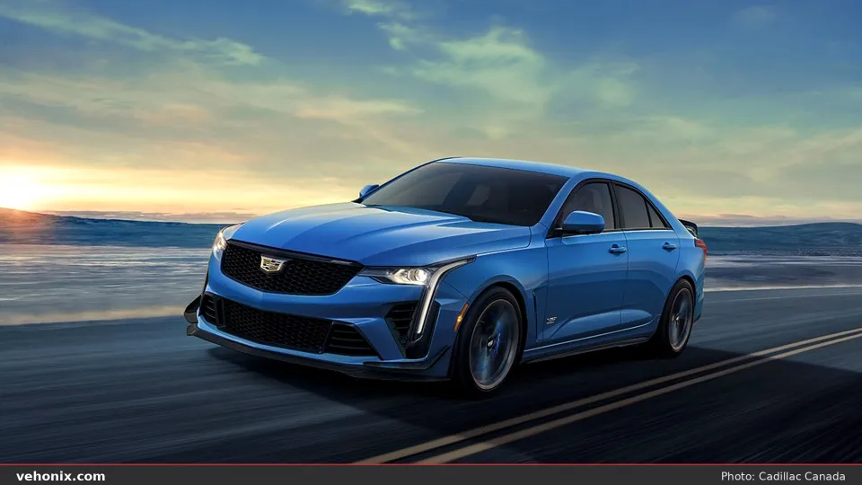 2026 Cadillac CT4-V in bright blue, front three-quarter driving at golden hour