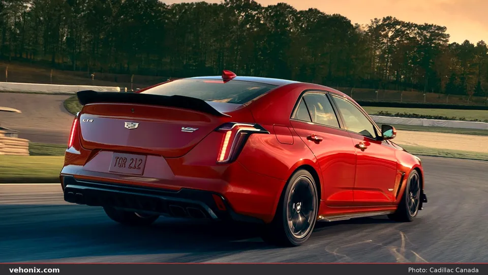 2026 Cadillac CT4-V in red, rear three-quarter on a racetrack at sunset