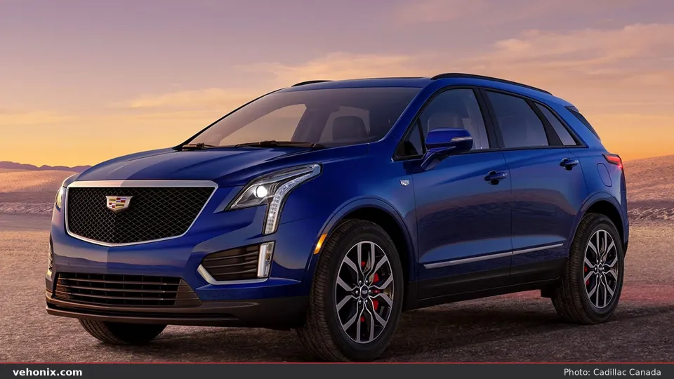 2026 Cadillac XT5 in dark blue, front three-quarter on desert ground at sunset