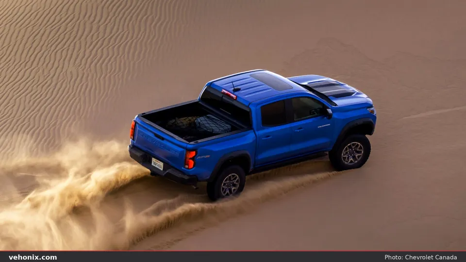 2026 Chevrolet Colorado Mud Terrain in blue, rear three-quarter view in sand