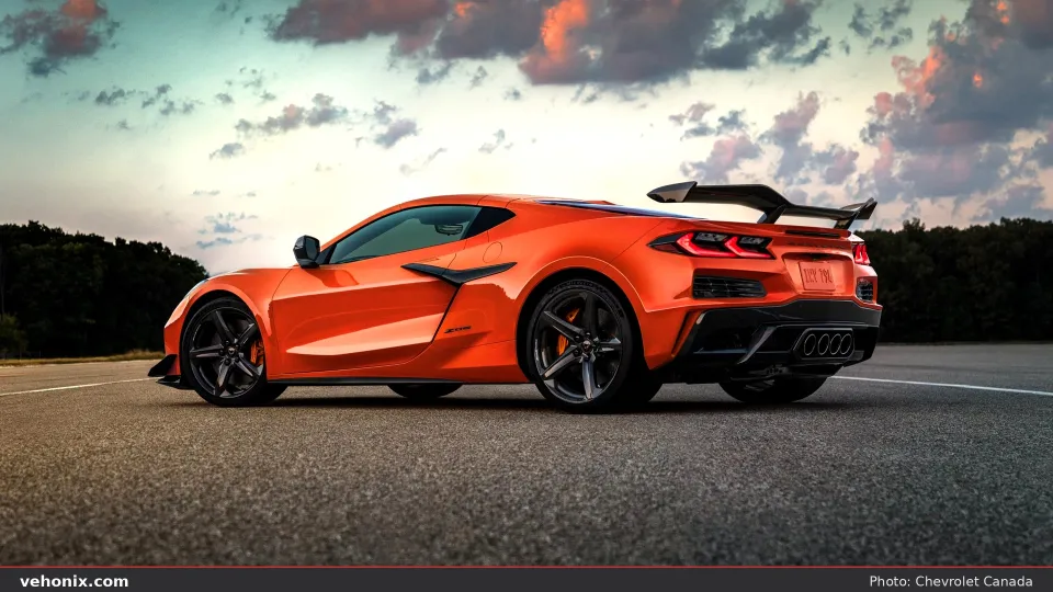 2026 Chevrolet Corvette Z06 Carbon Aero in orange, rear three-quarter view with wing