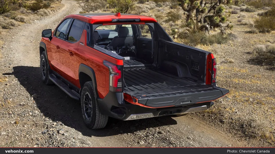 2026 Chevrolet Silverado EV Trail Boss Ext in red, rear three-quarter view with tailgate open