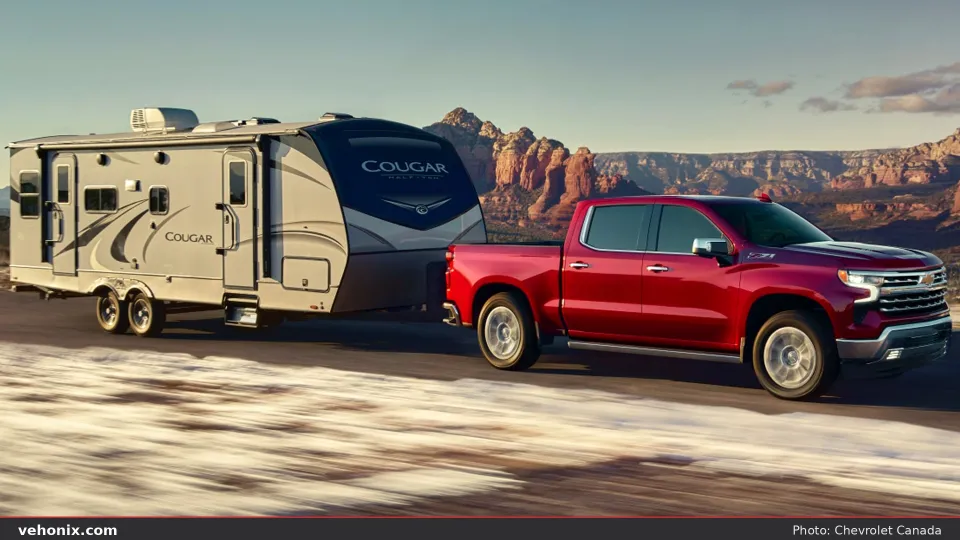 2026 Chevrolet Silverado in red, side view towing a trailer