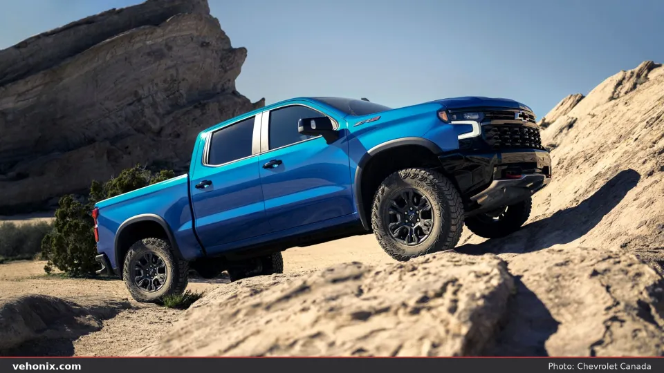 2026 Chevrolet Silverado Mud Terrain in blue, front three-quarter view on rocks