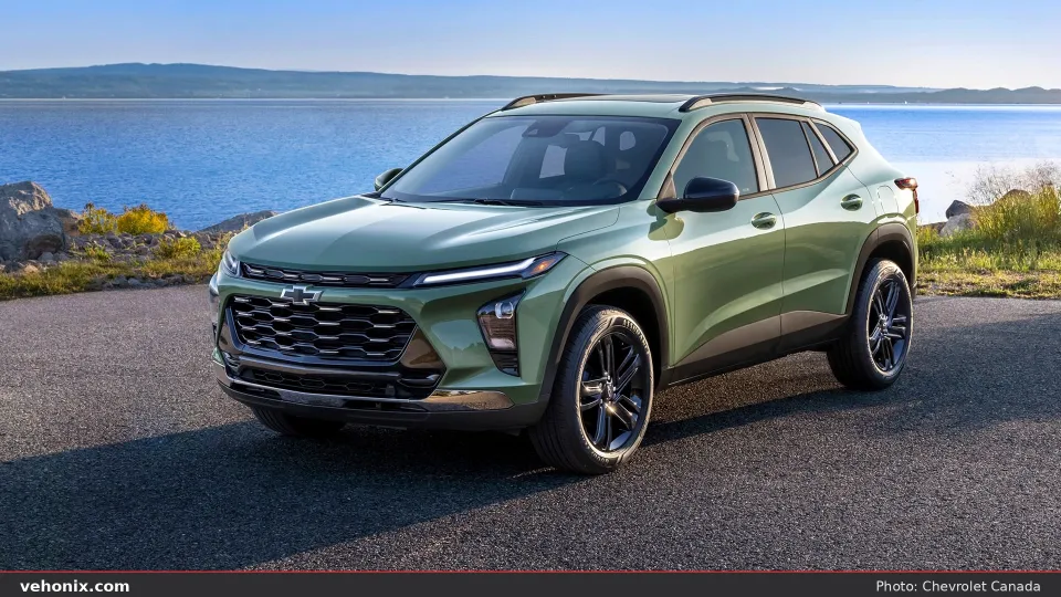 2026 Chevrolet Trax in sage green, front three-quarter beside a lake