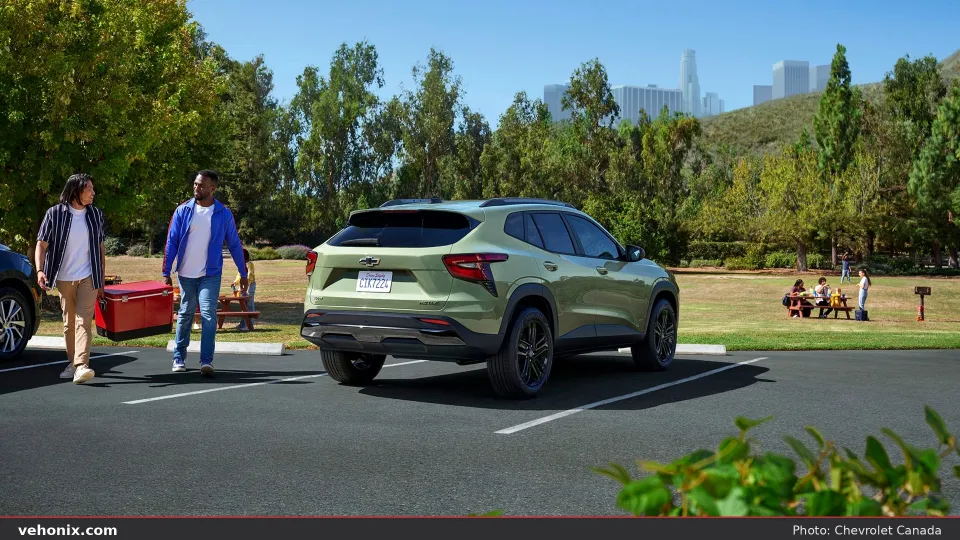 2026 Chevrolet Trax in sage green, rear three-quarter in a park parking lot