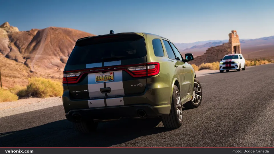 2026 Dodge Durango SRT Hellcat Jailbreak in Green Machine with silver stripes, rear three-quarter in desert