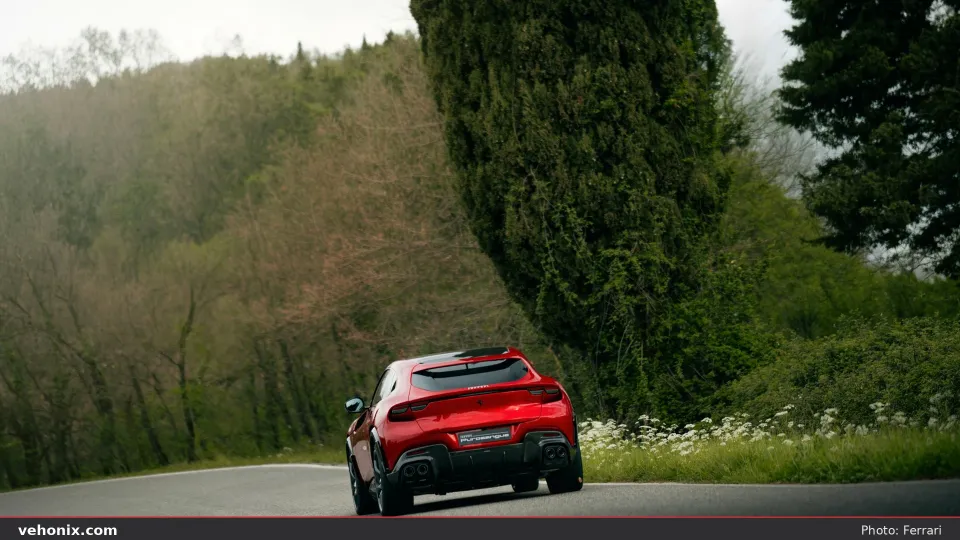 2026 Ferrari Purosangue Handling Speciale in red, rear three-quarter by cypress trees