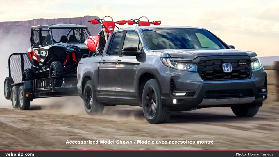 2026 Honda Ridgeline TrailSport towing a trailer with Honda off-road vehicles