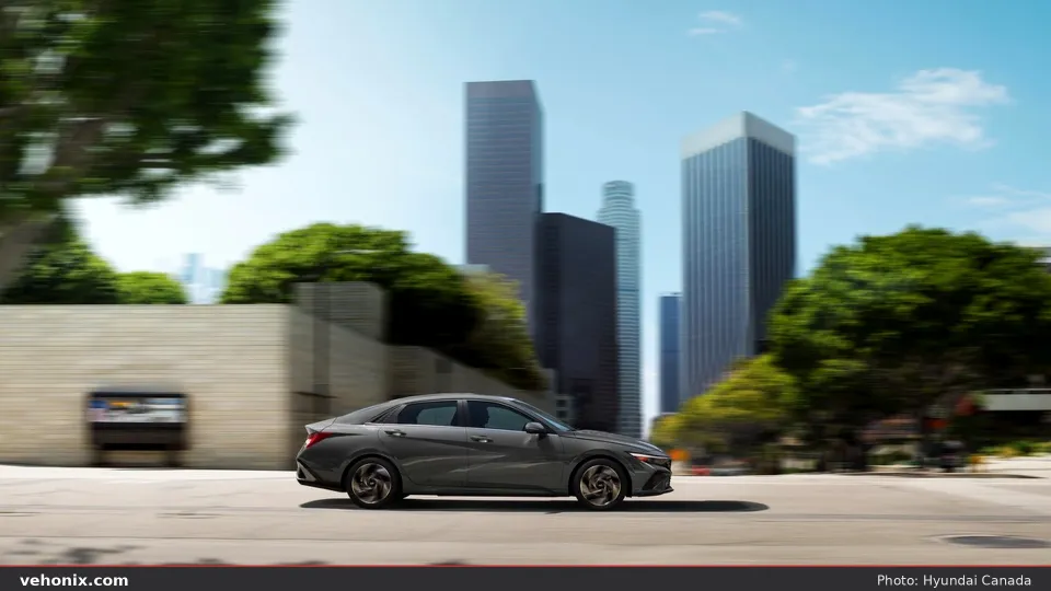 2026 Hyundai Elantra in dark grey, side profile driving through a city
