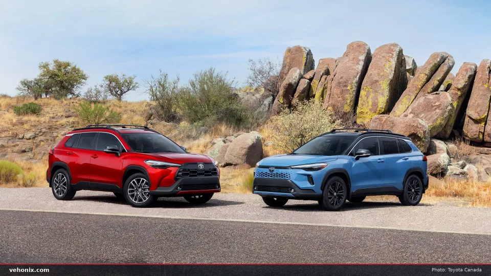 2026 Toyota Corolla Cross in red and blue, parked in front of desert rocks