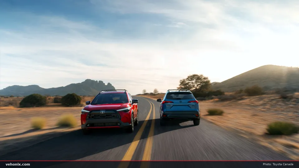 2026 Toyota Corolla Cross in red and blue, rear view driving on a desert road