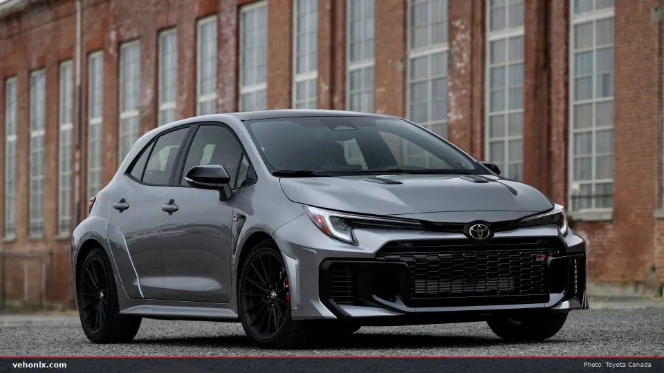 2026 Toyota GR Corolla Premium Plus in grey, front three-quarter view by a brick building