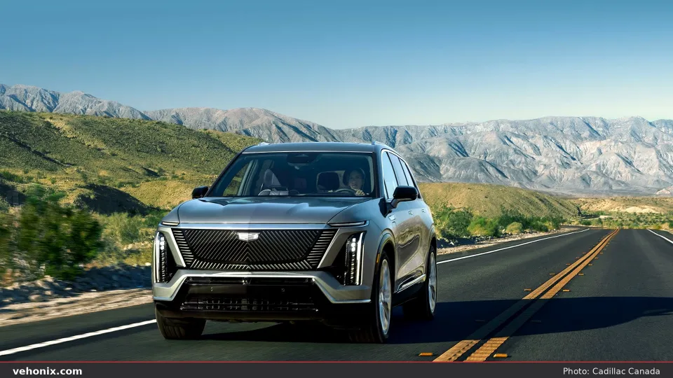 2026 Cadillac VISTIQ in silver, front three-quarter driving on a mountain road