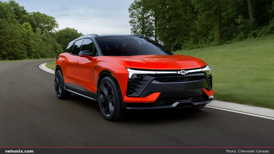 2026 Chevrolet Blazer EV in orange-red, front three-quarter on a winding road