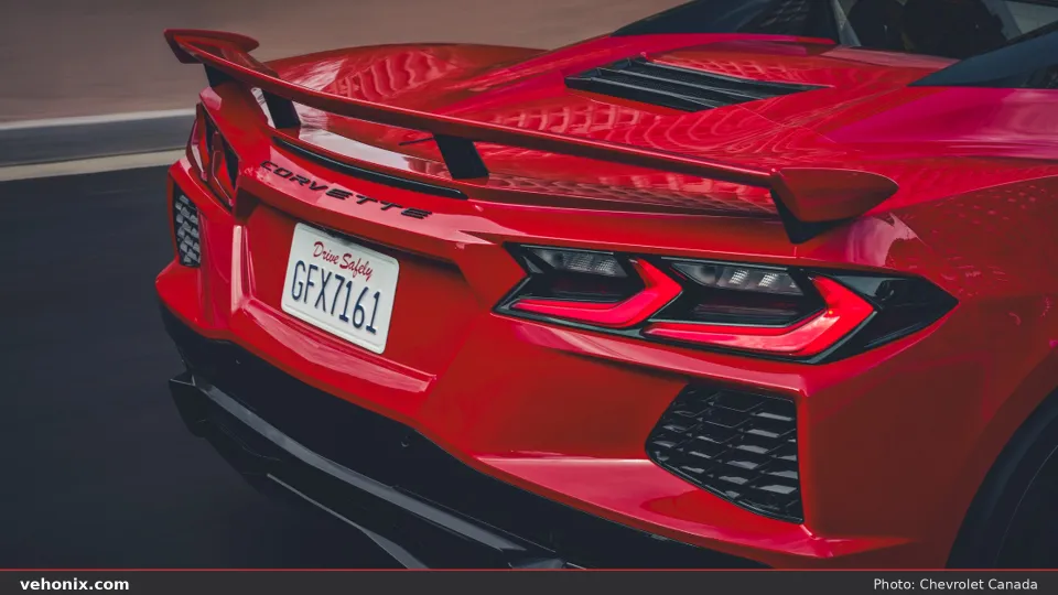 2026 Chevrolet Corvette in red, rear three-quarter with illuminated taillights