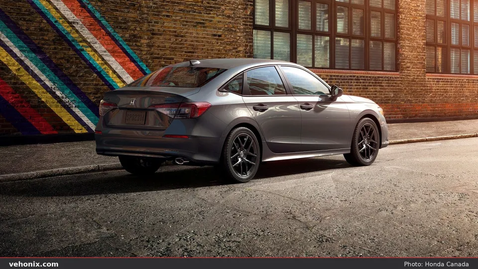 2026 Honda Civic Sport in Meteorite Gray, rear three-quarter by a mural wall