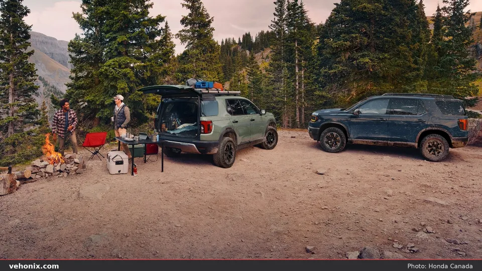 2026 Honda Passport TrailSport SUVs at a forest campsite with gear and campfire