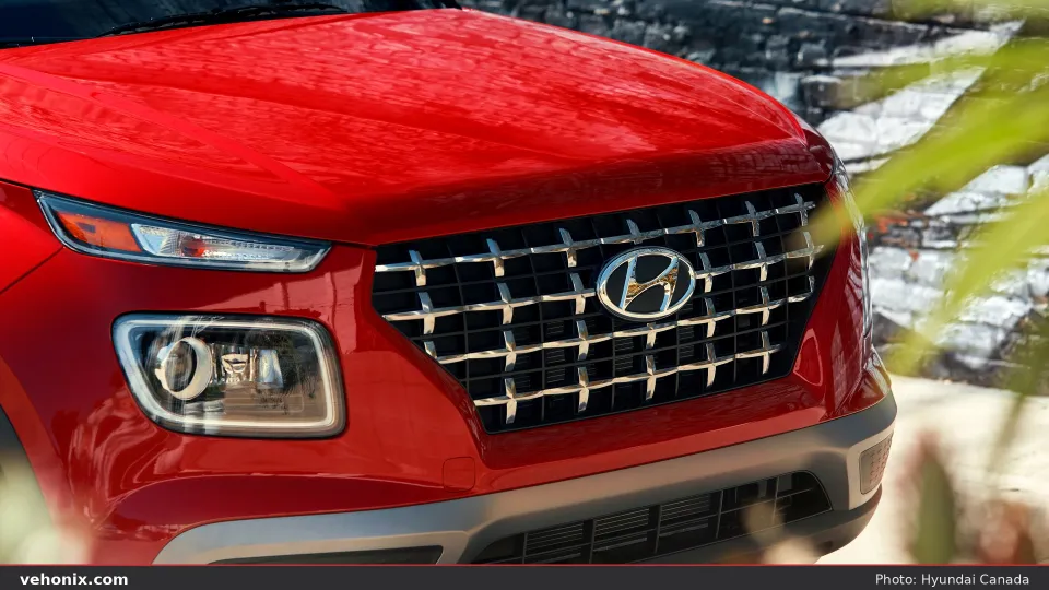 2026 Hyundai Venue in red, rear three-quarter driving at dusk