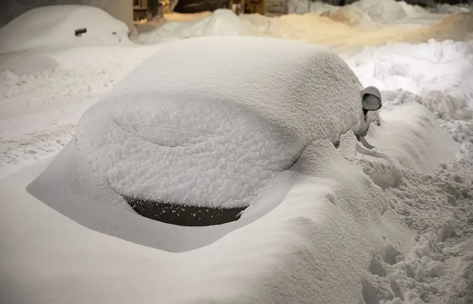 A car buried under snow on a street in Quebec City after a storm