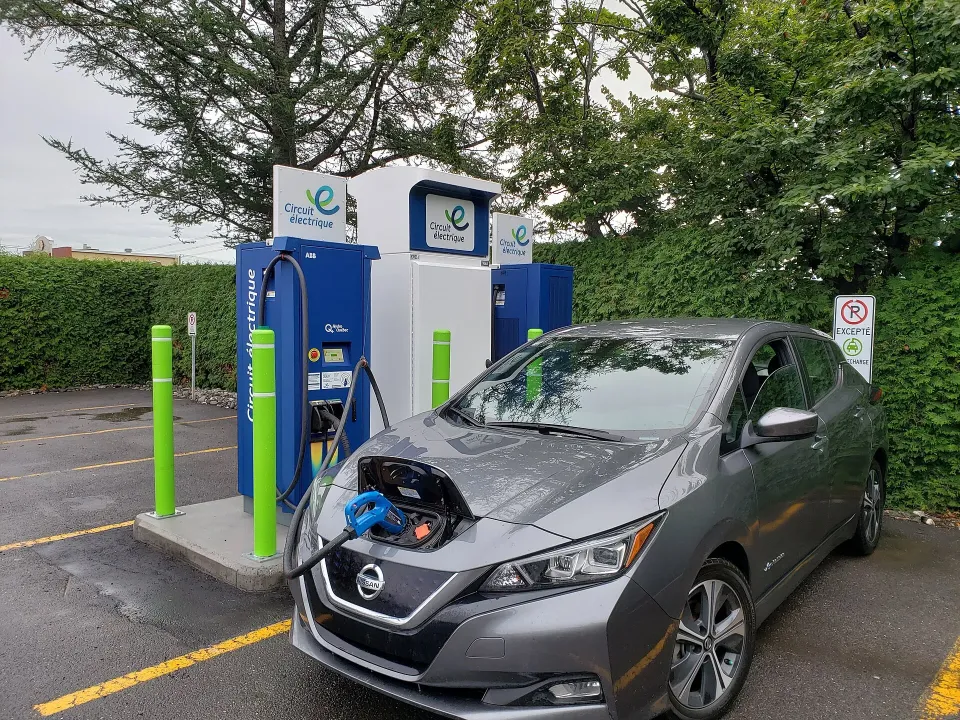 A grey Nissan Leaf charging at a Circuit électrique fast charger in Quebec