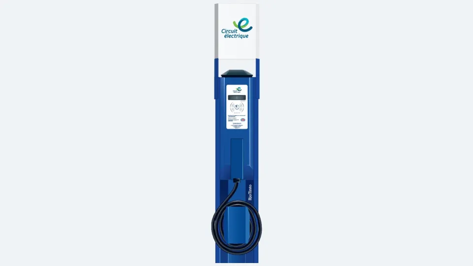 A blue Circuit électrique Level 2 EV charging station with its charging cable coiled on the front