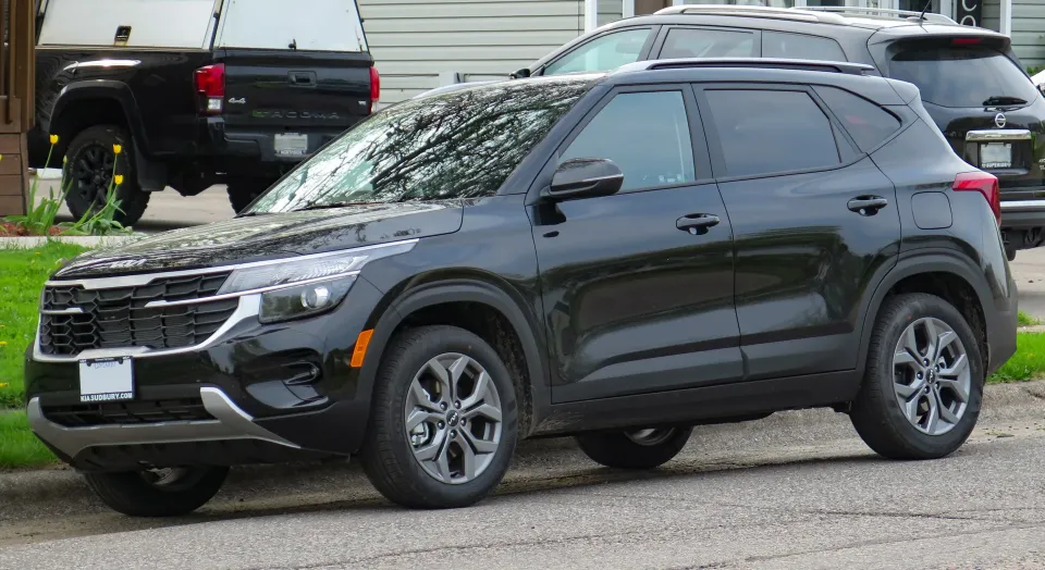 Black 2024 Kia Seltos LX parked on a residential street, front left view