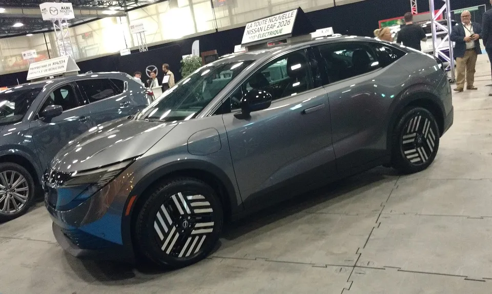 A blue 2026 Nissan Leaf on display at an auto show in Quebec