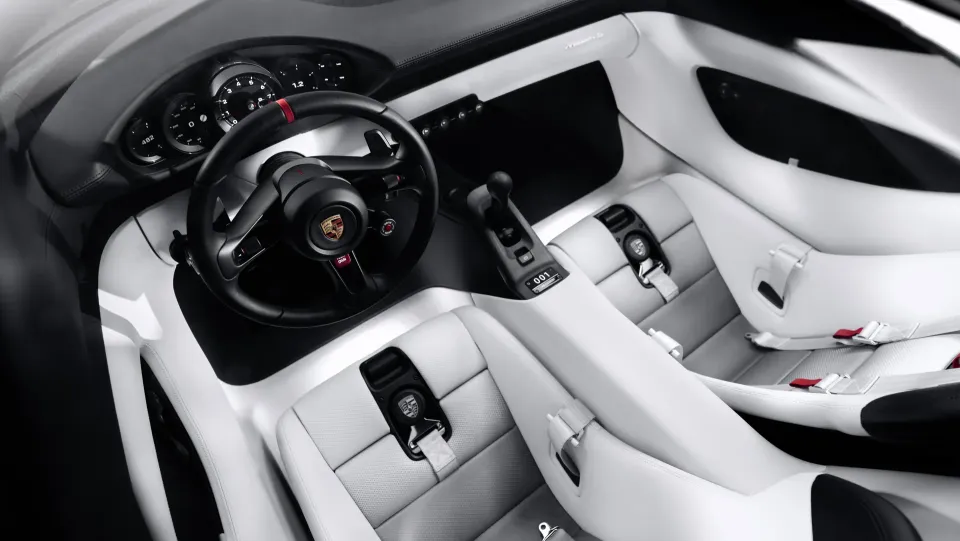 The white and grey interior of the Porsche Mission S with round gauges and a steering wheel