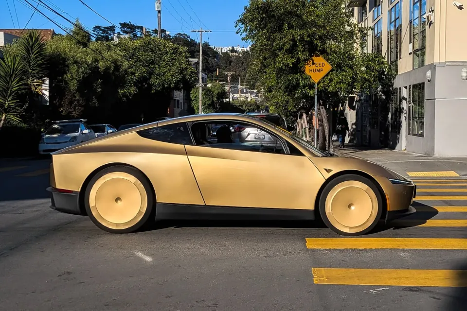 Un Cybercab de Tesla doré, sans conducteur visible, roule dans une rue de San Francisco