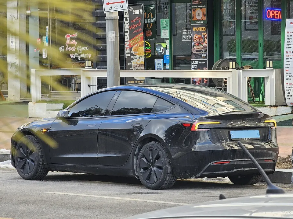 A black Tesla Model 3 parked outside